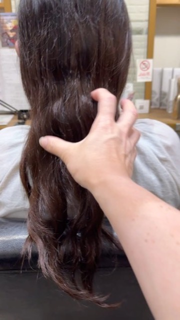 仕事で結べる長さを残すためにカット前の長さを確認している写真