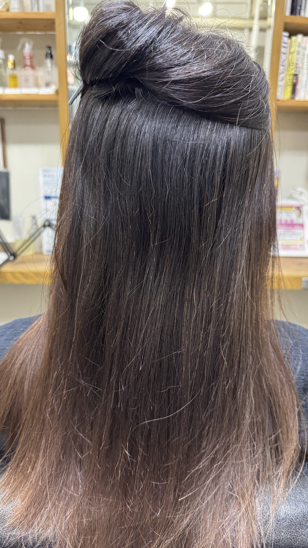 縮毛矯正履歴がある髪の内側に残るうねりを確認している写真