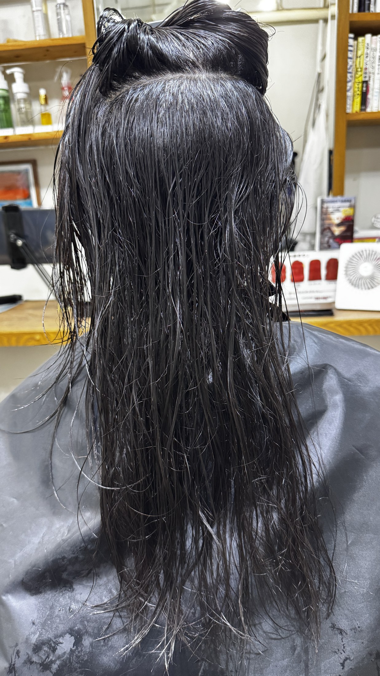表面をめくって内側のワッフル状の細かいクセを確認している黒髪ロングの施術前