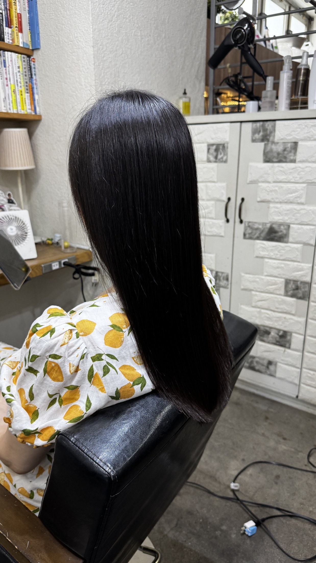 縮毛矯正後に細く柔らかい黒髪ロングの艶とまとまりが出た左後ろからの仕上がり