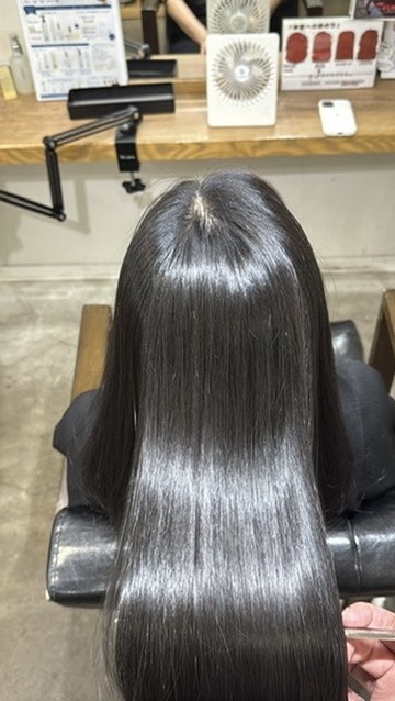 縮毛矯正後メンテナンスでトップから毛先まで艶を確認している黒髪ロング