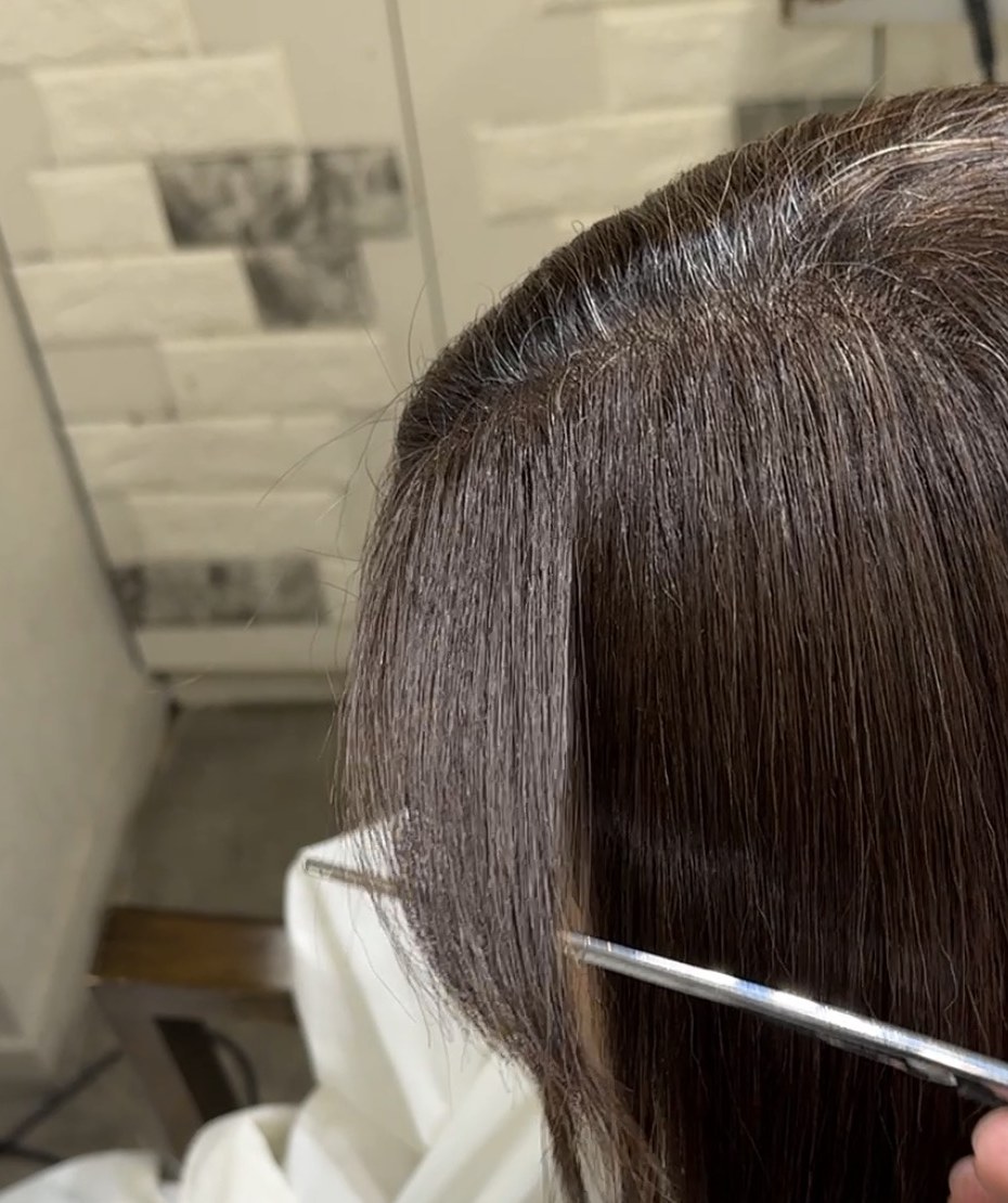 前髪縮毛矯正後に根元と毛先の差をなじませ、柔らかく落ちる状態を確認している写真