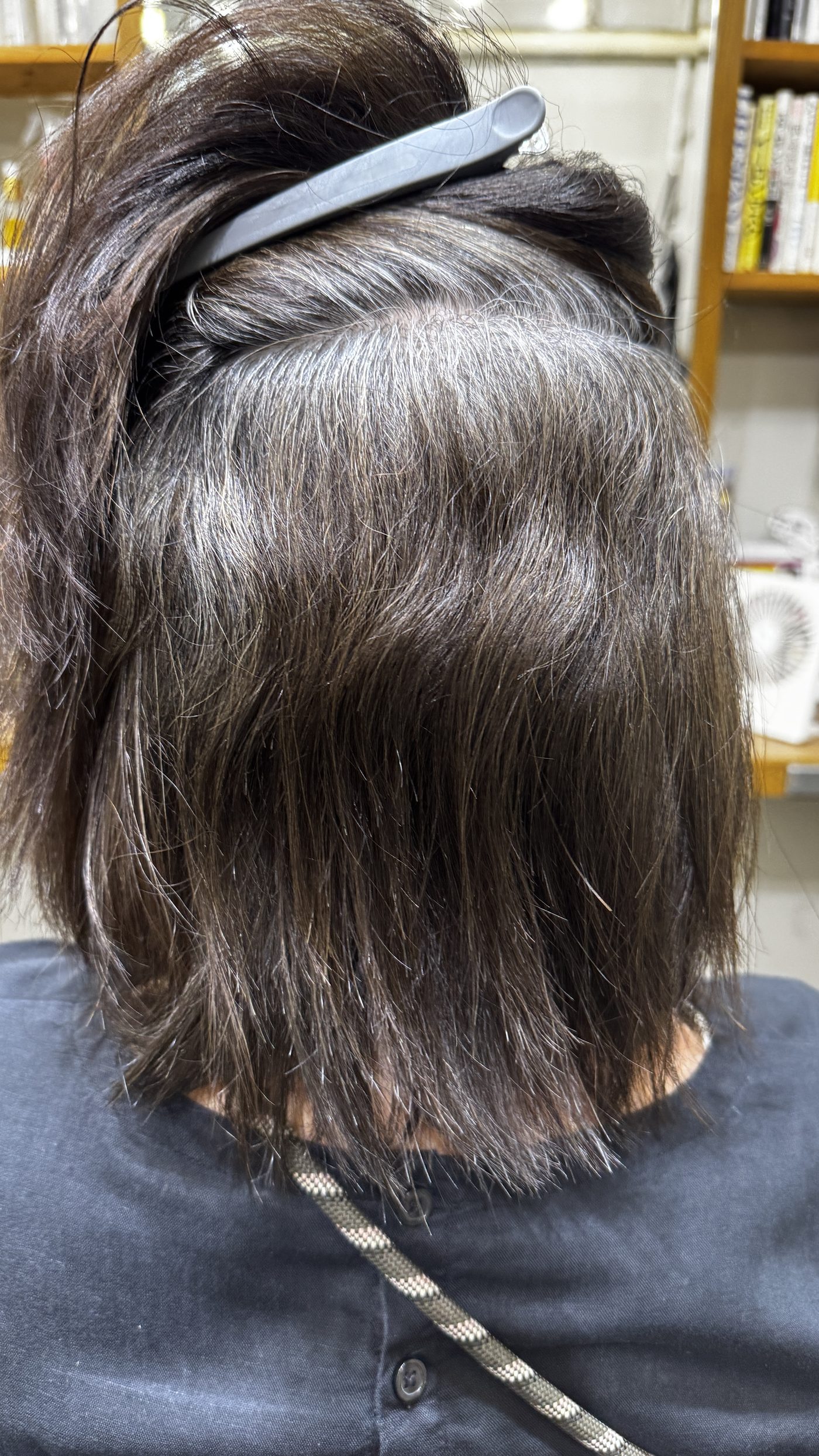 表面をめくって内側の根元のうねりと白髪混じりのクセを確認している状態